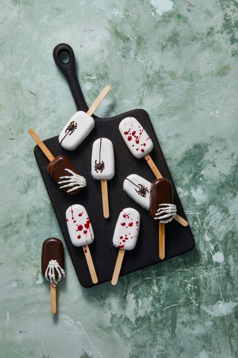 halloween cake pops decorated with skeletons, blood, and chocolate spiders
