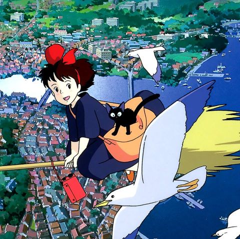 kiki and jiji fly high above town on a broom in a scene from kiki's delivery service, a good housekeeping pick for best halloween movies for kids