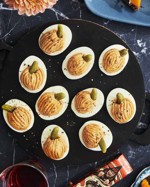 smokey pumpkin deviled eggs on a black serving tray