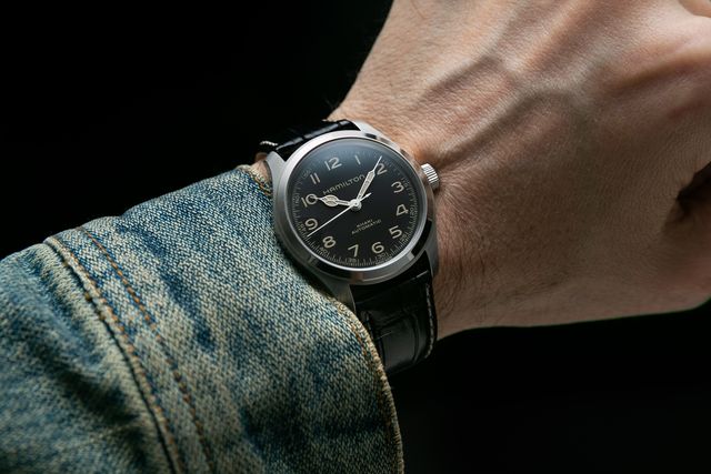 man wearing a watch on his wrist with a jean jacket
