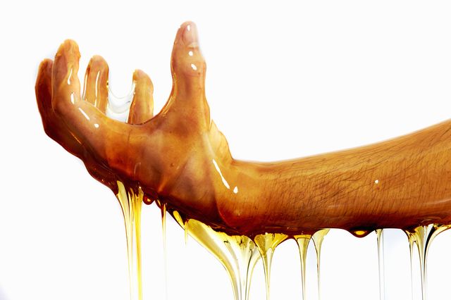 hand and arm covered and dripping with honey