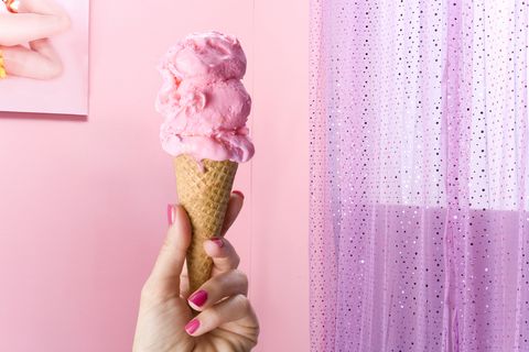 hand holding ice cream cone in pink bedroom