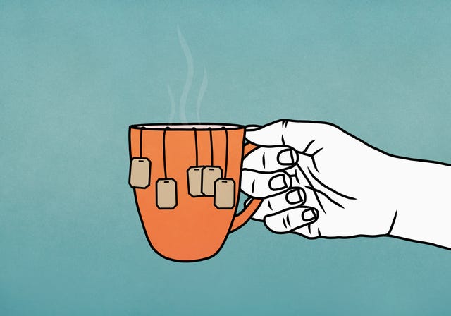 cómo preparar la taza de té perfecta según la ciencia mano sosteniendo una taza con muchas bolsas de té