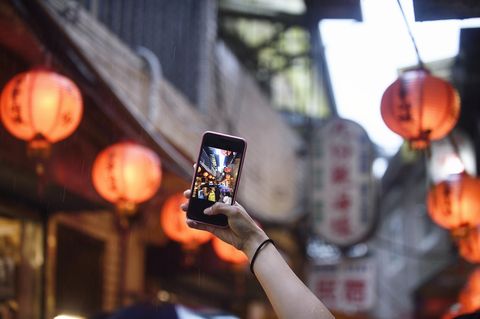 hand taking a picture of chinese lanterns with a smart phone