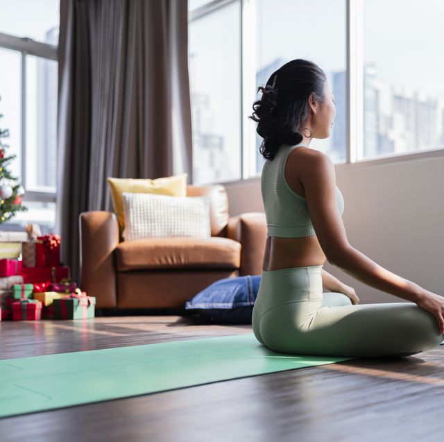 happiness healthy asian female woman in yoga work out cloth doing yoga exercise against christmas tree,asian female woman spending christmas holiday morning time do yoga workout in living room at home morning activity healthy lifestyle