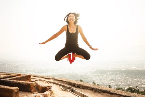 happiness japanese woman jumping on top of the rock