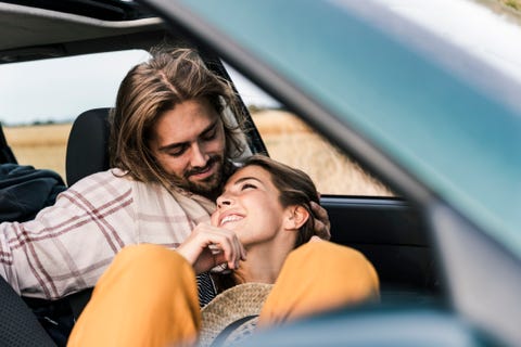 happy affectionate young couple in a car