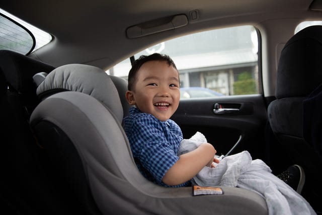 anak laki-laki bahagia di dalam mobil