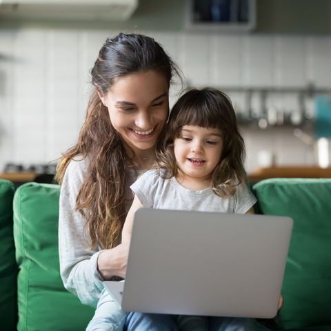 happy laughing mother and daughter using laptop