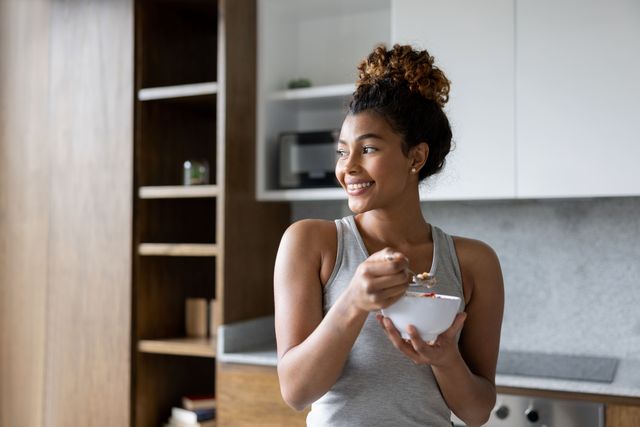 woman smiling eating bowl of yoghurt