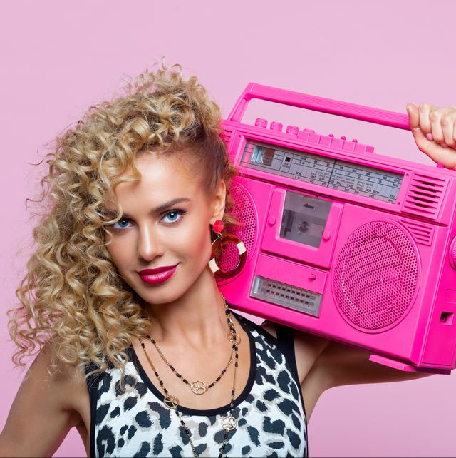 happy woman in 80's style outfit holding boom box