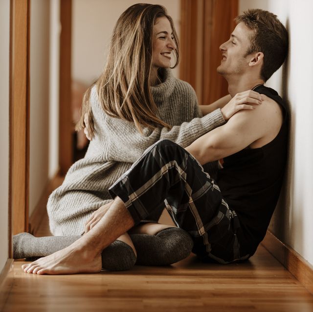 happy young couple sitting on the floor at home