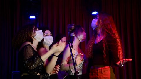 jóvenes con mascarilla divirtiéndose en un karaoke