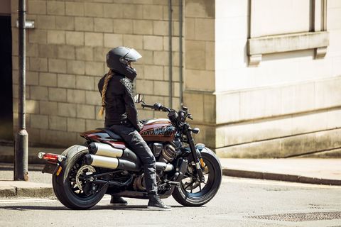 woman sitting on harley davidson sportster s motorcycle