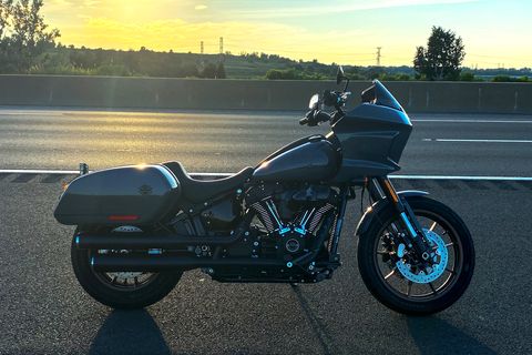 harley low rider st motorcycle on side of road during sunset