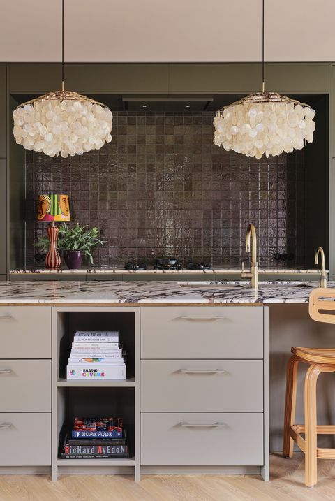 amsterdam home of actor carice van houten designed by nicole dohmen of atelier nd interior kitchen earthy tones though violet still makes an appearance in the calacatta marble counter backsplash tile intercodam pendants verpan cabinetry custom paint invisible green, little greene cabinets mouse’s back, farrow  ball island cooktop pitt cooking faucet quooker