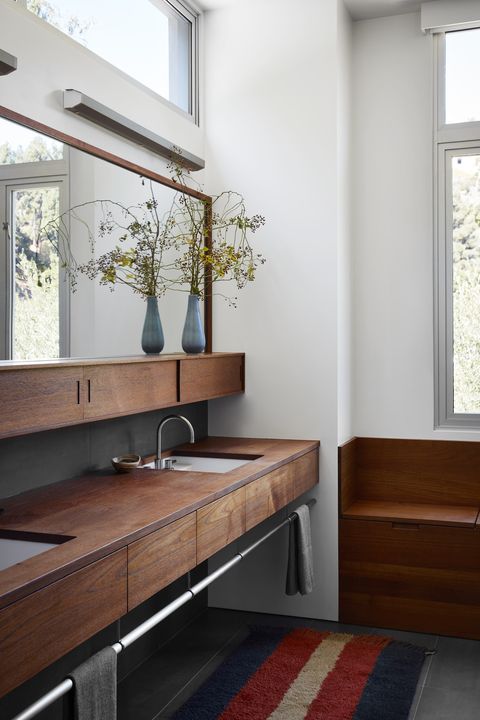 bathroom
the designer “chose minimal finishes and millwork
that didn’t distract from the nature outside” paint
all white, farrow  ball sconces rich brilliant willing millwork teak, northstar cabinet construction