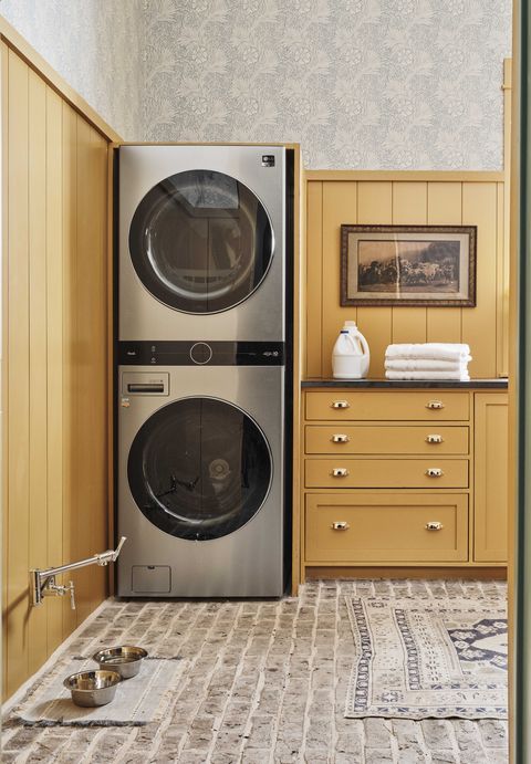 laundry, yellow cabinets, pet water bowl, washer and dryer, rug, white towels