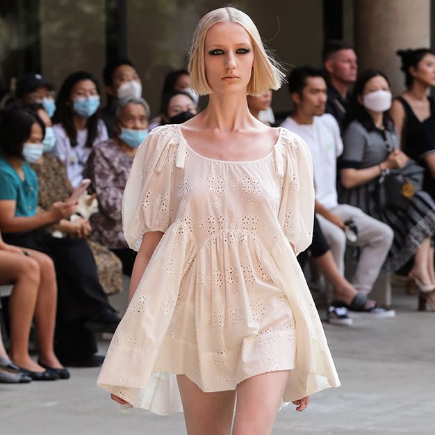 a model walks the sandy liang spring summer 2022 runway wearing a babydoll dress and sneakers