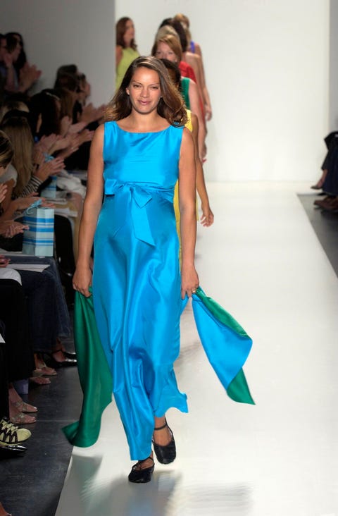 model walks down runway in blue and green dress