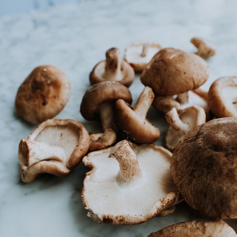 bunch of wholesome fresh shiitake mushrooms on marble background