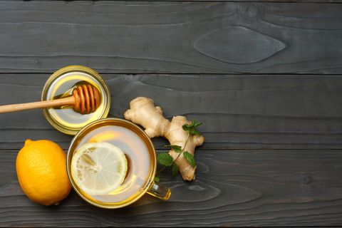 healthy background. honey, honeycomb, lemon, tea, ginger on dark wooden table. Top view with copy space