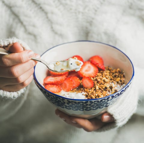 Healthy breakfast yogurt, granola, strawberry bowl in woman's hands Healthy breakfast yogurt, granola, strawberry bowl in woman's hands