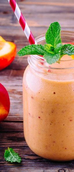 healthy nectarine smoothies in a mason jar with mint on wooden background