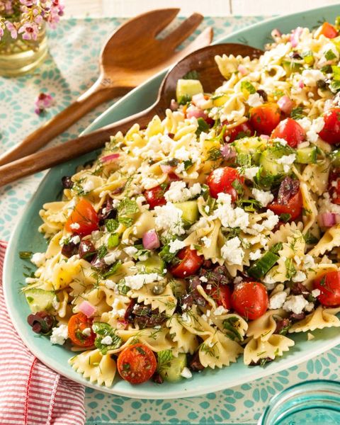 greek pasta salad with wooden spoons