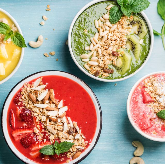 Healthy summer breakfast concept. Colorful fruit smoothie bowls on turquoise