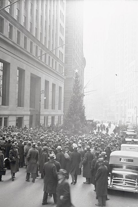 people viewing large christmas tree on wall street