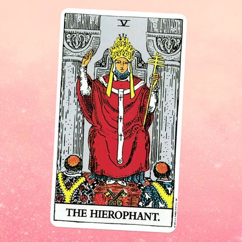 the tarot card The Hierophant, showing a person in a red robe and a golden crown seated on a throne, with two people kneeling in front of them