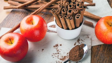 High Angle View Of Apples With Cinnamons In Cup On Table