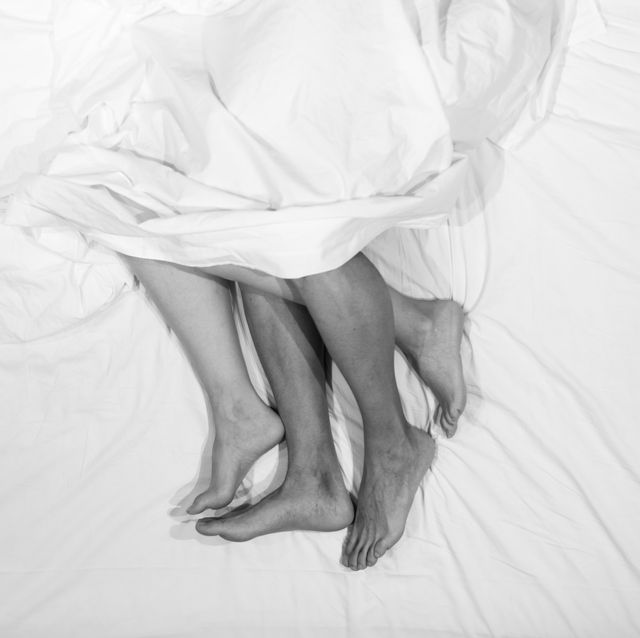 high angle view of barefoot couple relaxing on bed