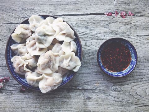Chinese Dumpling And Chili Oil Served In Bowls On Wooden Table