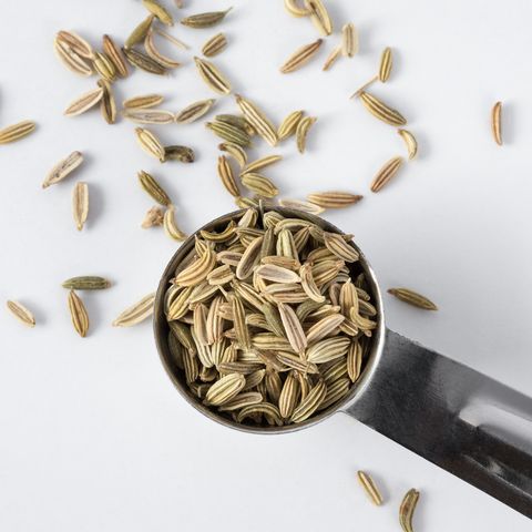 High Angle View Of Fennel Seeds In Measuring Spoon Against White Background
