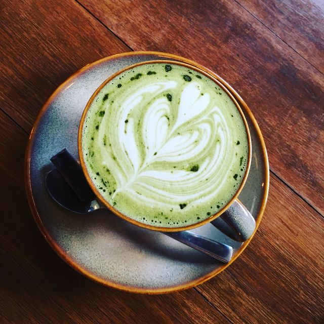 high angle view of matcha tea with froth art at table