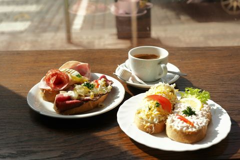 high angle view of open sandwiches on plate with espresso coffee cup on table