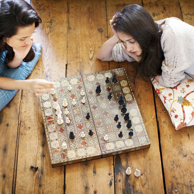 high angle view of sisters playing chess at home