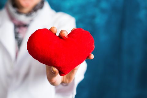 Female doctor holding a red heart closeup