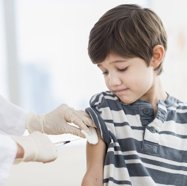 hispanic boy getting a shot at doctor's office