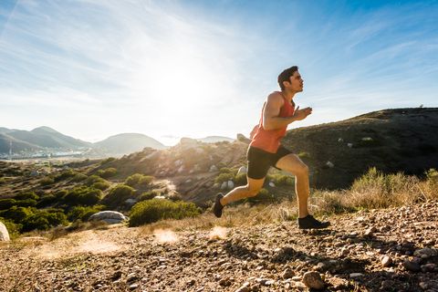 Hispanic Male Running Up A Steep Hill In The Mountains