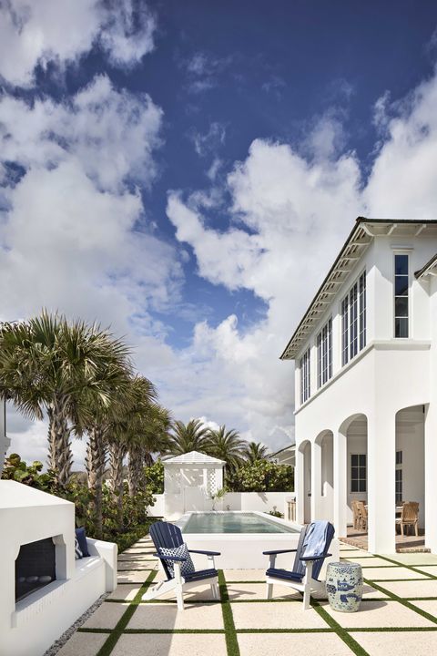 outdoor exterior, pool, large concrete tiles, grass, blue and white lounge chairs