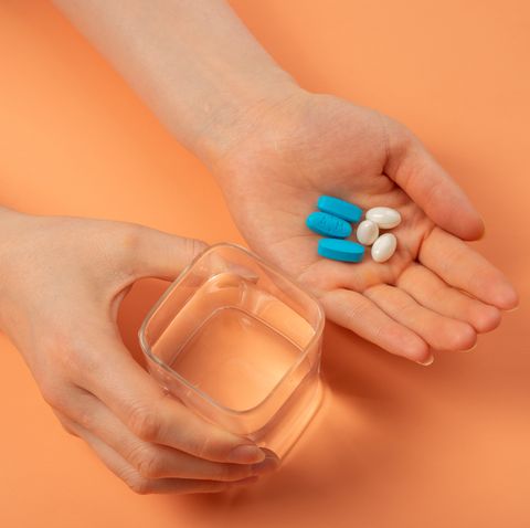 holding pill in hand with water