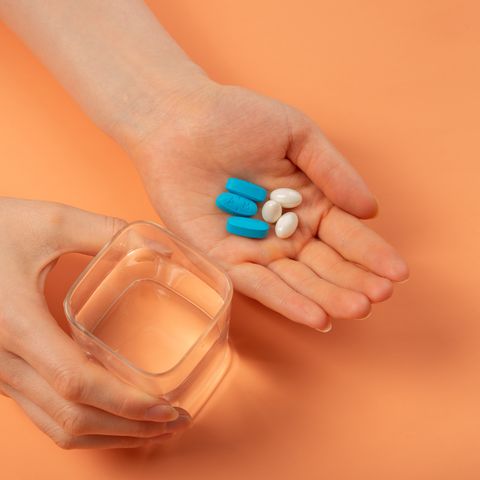 holding pill in hand with water
