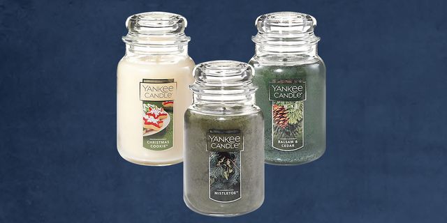 three holiday yankee candles with a dark blue background
