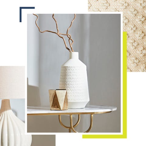 a white textured vase, sitting with a gold ornament on a marble side table