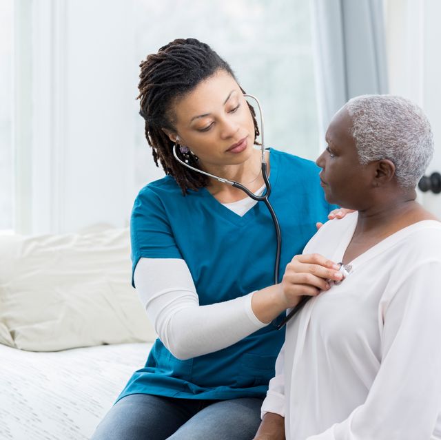 Home healthcare nurse examines elderly patient