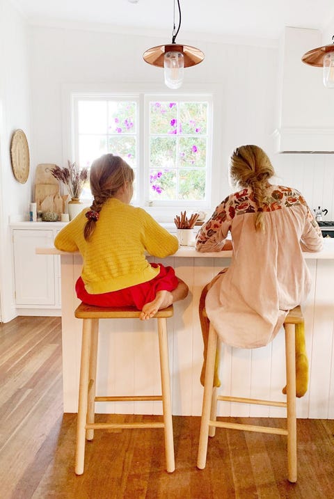 two girls doing homework at kitchen island