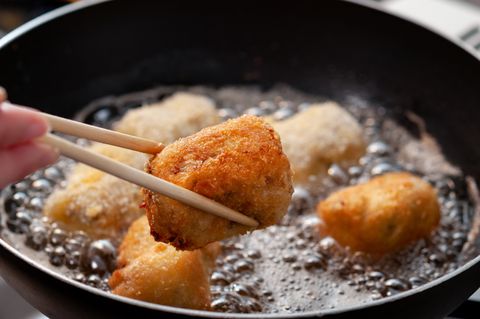 homemade croquettes being cooked in a pan filled with cooking oil
a scene of the kitchen  in japan